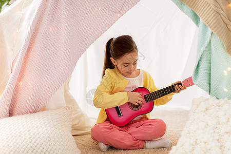 童潮湿的快乐的小女孩孩子们的帐篷里弹玩具吉他女孩家孩子们的帐篷里弹玩具吉他女孩家孩子们的帐篷里弹玩具图片