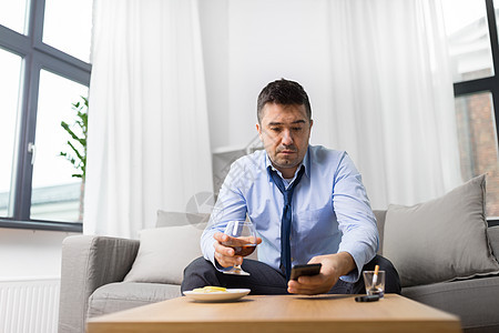 酗酒,酗酒人们的观念醉酒的人家里智能手机杯白兰地家里智能手机酒精的醉汉家里智能手机酒精的醉汉图片