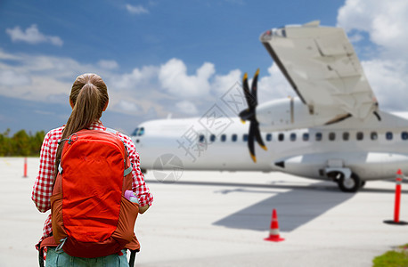 航空旅行,旅游旅行旅游妇女与背包飞机上的机场背景带背包的旅游妇女乘飞机旅行带背包的旅游妇女乘飞机旅行图片