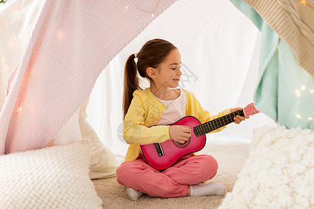 童潮湿的快乐的小女孩孩子们的帐篷里弹玩具吉他女孩家孩子们的帐篷里弹玩具吉他女孩家孩子们的帐篷里弹玩具图片