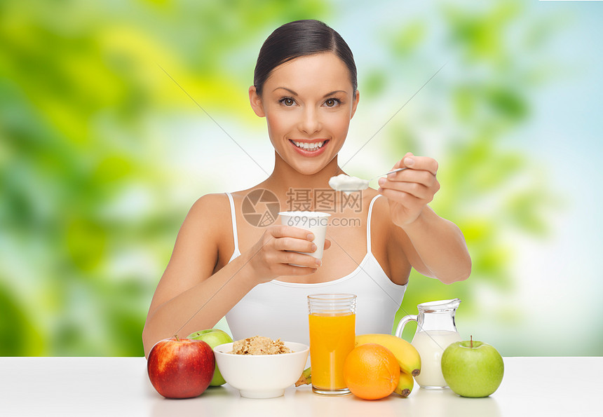 饮食,健康食品人的女人与水果吃酸奶早餐绿色的自然背景带水果的女人早餐吃酸奶带水果的女人早餐吃酸奶图片