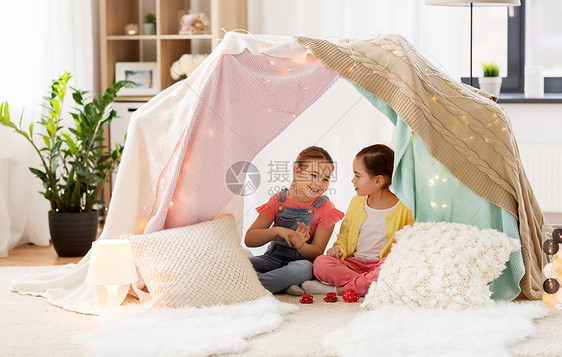 童潮湿的快乐的小女孩玩茶玩具陶器孩子们的帐篷家里小女孩家孩子们的帐篷里玩茶话会小女孩家孩子们的帐图片