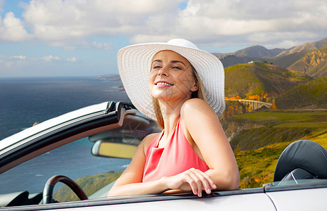 年轻女人戴着太阳帽在敞篷汽车上图片