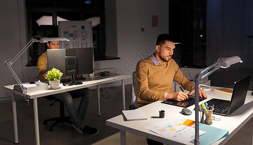 商业,技术,人的轻的创意男子平师与笔记本电脑工作的笔式平板电脑深夜办公室办公室电脑平板电脑的人设图片