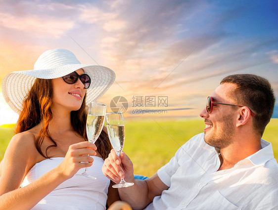 庆祝人们的微笑的夫妇傍天空背景下野餐时喝香槟微笑的夫妇野餐时喝香槟微笑的夫妇野餐时喝香槟图片