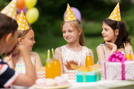 假期,童庆祝快乐的孩子坐桌子上的生日聚会夏季花园快乐的孩子夏季花园的生日聚会上快乐的孩子夏季花园的生日图片