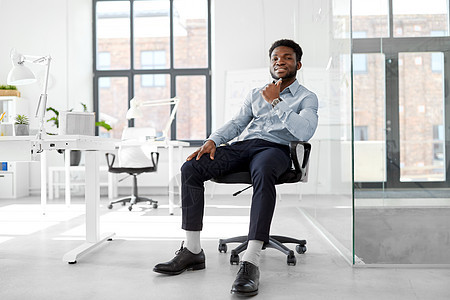 商业人的微笑的非裔美国商人坐办公椅上非洲商人坐办公椅上非洲商人坐办公椅上图片