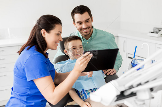 医学,牙科医疗保健牙医向儿童病人他的父亲牙科诊所展示平板电脑牙医牙科诊所向孩子展示平板电脑牙医牙科诊所向图片