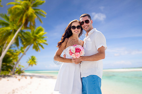旅行,旅游暑假的幸福的微笑夫妇与鲜花拥抱热带海滩背景法属波利尼西亚热带海滩上花的幸福夫妇热带海滩上图片