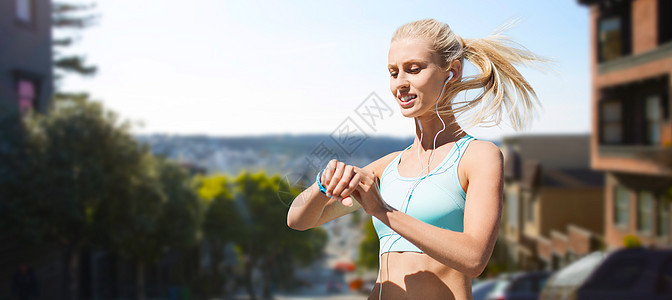 运动,技术健康的生活方式微笑的轻妇女与健身跟踪耳机锻炼旧金山城市背景健身追踪器的女人运动健身追踪器的图片