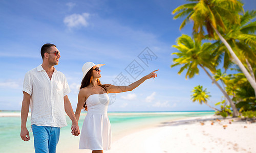 旅行,旅游暑假的快乐的夫妇度假时戴着太阳镜,手牵手热带海滩背景下行走法属波利尼西亚快乐的夫妇热带海滩度假图片