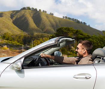 公路旅行,旅行人们的快乐的人驾驶敞篷汽车大苏尔山背景加利福尼亚开敞篷车的快乐男人图片