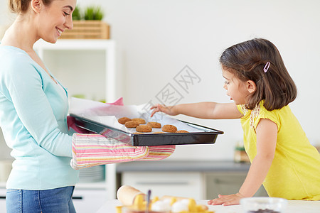 家里的厨房快乐的母亲和女儿烤饼干图片