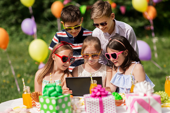 假期,童技术快乐的孩子戴太阳镜与平板电脑生日聚会夏季花园生日派上平板电脑的快乐孩子图片