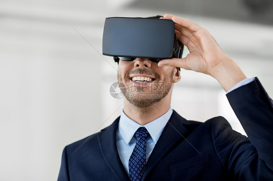商业,技术增强现实微笑商人与VR耳机办公室办公室配备虚拟现实耳机的商人图片