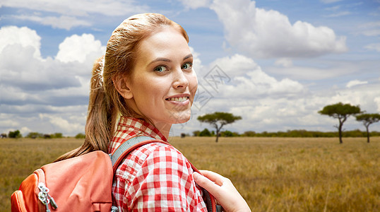 冒险,旅行,旅游,徒步旅行人的微笑的轻女人带着背包非洲热带草原的背景快乐的女人带着背包非洲草原上图片
