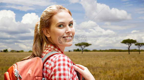 冒险,旅行,旅游,徒步旅行人的微笑的轻女人带着背包非洲热带草原的背景快乐的女人带着背包非洲草原上图片