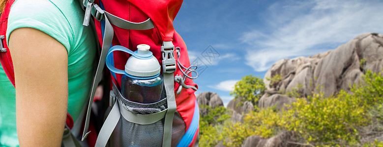 旅行,旅游,徒步旅行人们的塞舌尔岛的背景下,把带水瓶的女人关背包口袋里把带水瓶的女人关背包里背景图片