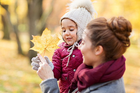 家庭,季节人的快乐的母亲小女儿秋天的公园枫叶快乐的母亲小女儿秋天的公园图片