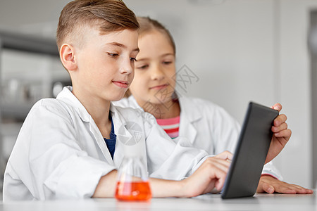 学校实验室学化学用平板电脑的孩子图片