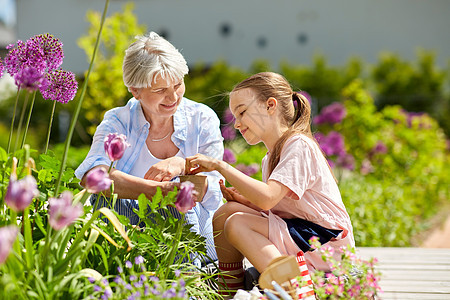 快乐的祖母孙女夏季花园播种花图片