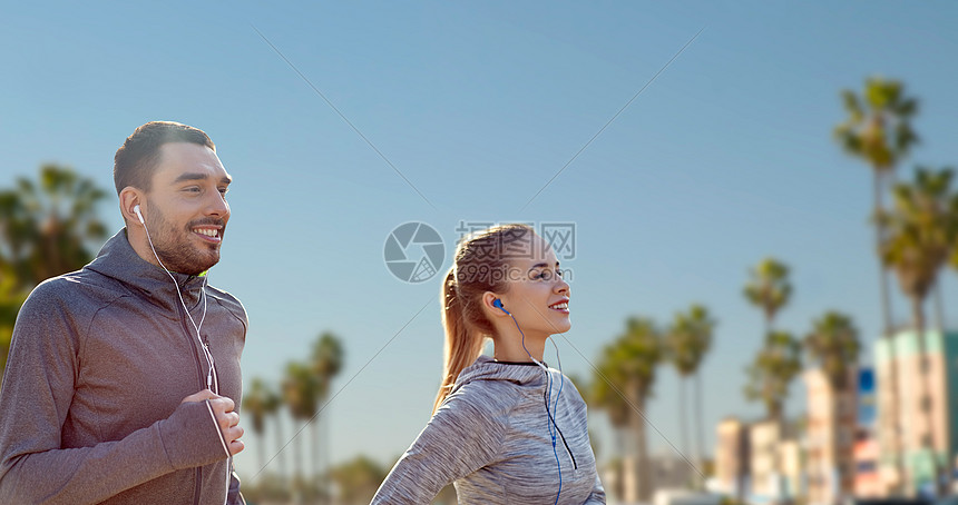 健身,运动技术快乐的夫妇跑步听音乐耳机威尼斯海滩背景加利福尼亚夫妇带着耳机跑过威尼斯海滩图片