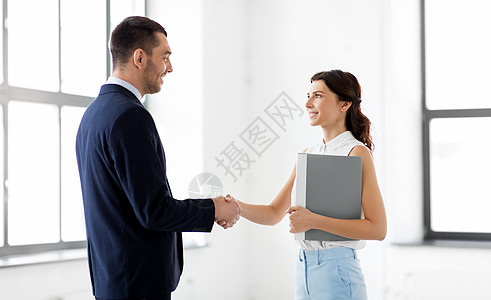 商人,合作伙伴合作理念快乐微笑的女商人与文件夹商人办公室握手女商人商人握手图片