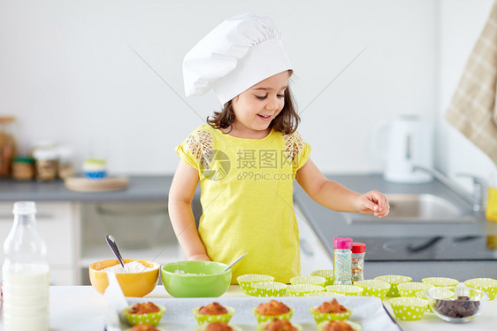 家庭,烹饪人的小女孩厨师烤松饼纸杯蛋糕洒家里厨师里的小女孩家烤松饼图片