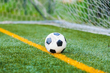 足球个球门网背景的足球人工场上人造草地上的足球图片