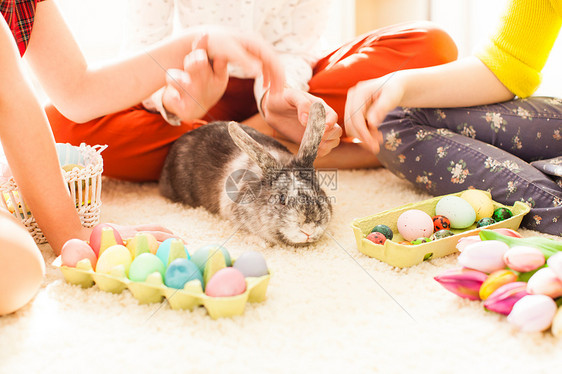 穿着兔子耳朵的女朋友坐地板上玩复活节兔子假期准备的女朋友玩兔子图片