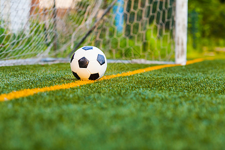 足球个球门网背景的足球人工场上人造草地上的足球背景图片