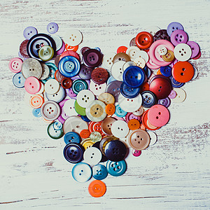 五颜六色的纽扣老式木桌上的心形五颜六色的纽扣心图片