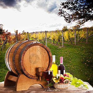 葡萄装瓶的葡萄酒靠近木桶桌上的杯酒,酒厂的红色白色酒庄的图片