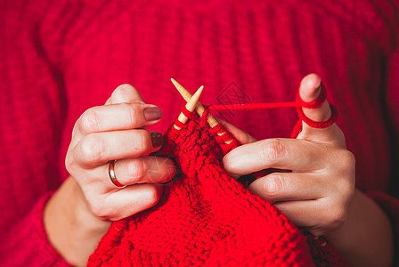 握住针头编红色温暖夹克的手女手针毛衣图片