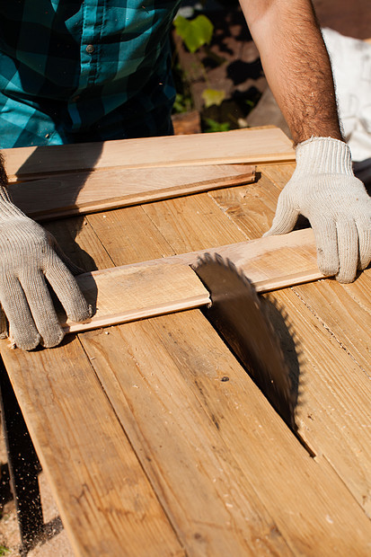 辛勤工作的木工切割木板,专注于锯锯木厂努力工作图片