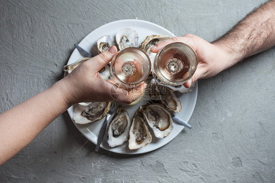 美味的牡蛎,柠檬片杯白葡萄酒,顶级景观异国风味的菜肴带葡萄酒的牡蛎图片