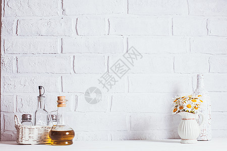 家庭内部装饰,白色花瓶中的雏菊花,装饰白色瓶子篮子中的璃瓶油家庭内部装饰图片