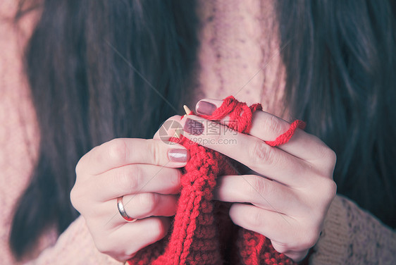 握住针头编红色温暖夹克的手女手针毛衣图片