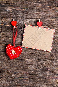 红色的心纸卡挂绳子上,红色的夹子乡村的背景上情人节的图片