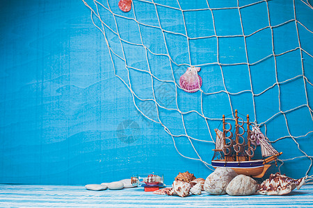 美丽的海洋成与玩具帆船,贝壳,璃瓶渔网蓝色背景海洋内部装饰图片