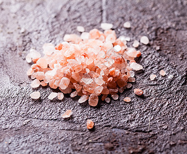石板背景上的粉红色喜马拉雅海盐各种盐的元图片