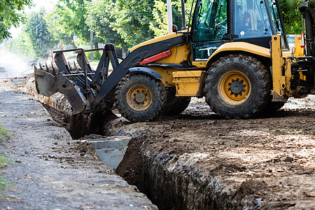 挖掘机睡着了条沟渠郊区的建筑挖掘机工作时背景图片