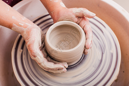 儿童陶瓷工艺品用白色粘土陶工轮上制作陶器的女孩的手儿童陶瓷工艺品图片