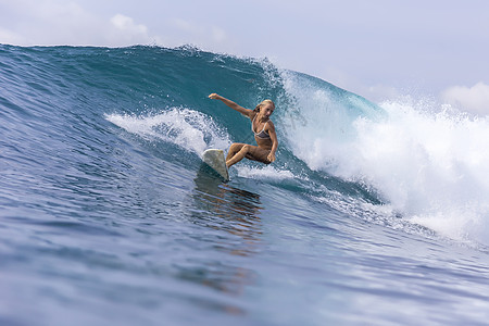 冲浪女孩波浪上,巴厘岛,印度尼西亚图片