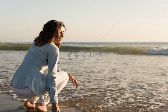 美丽的女人海滩上享受日落图片