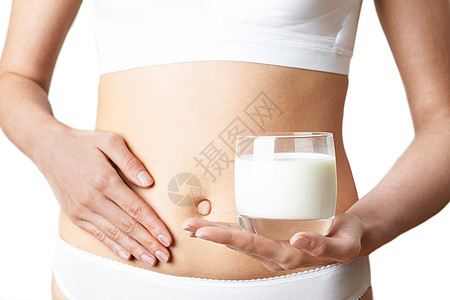 靠近穿内衣的女人,喝杯新鲜牛奶,摸肚子图片