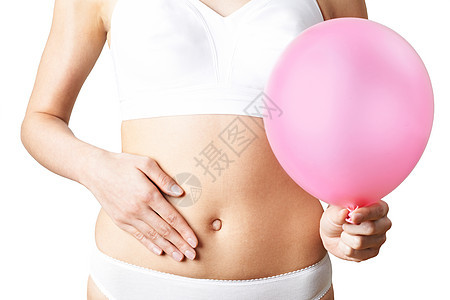 特写穿内衣的女人着粉红色的气球,摸着肚子图片