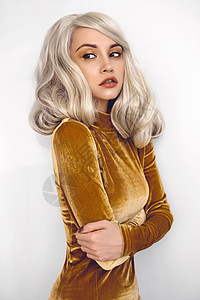 时尚工作室肖像轻美丽的金发女郎穿着棕色天鹅绒连衣裙图片