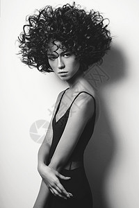 黑白时尚工作室肖像的美丽女人穿着黑色连衣裙与AFR卷发发型时尚美丽图片