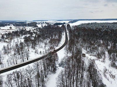 冬季森林道路弯道的鸟瞰图冬季雪景,河流森林道路草地背景图片